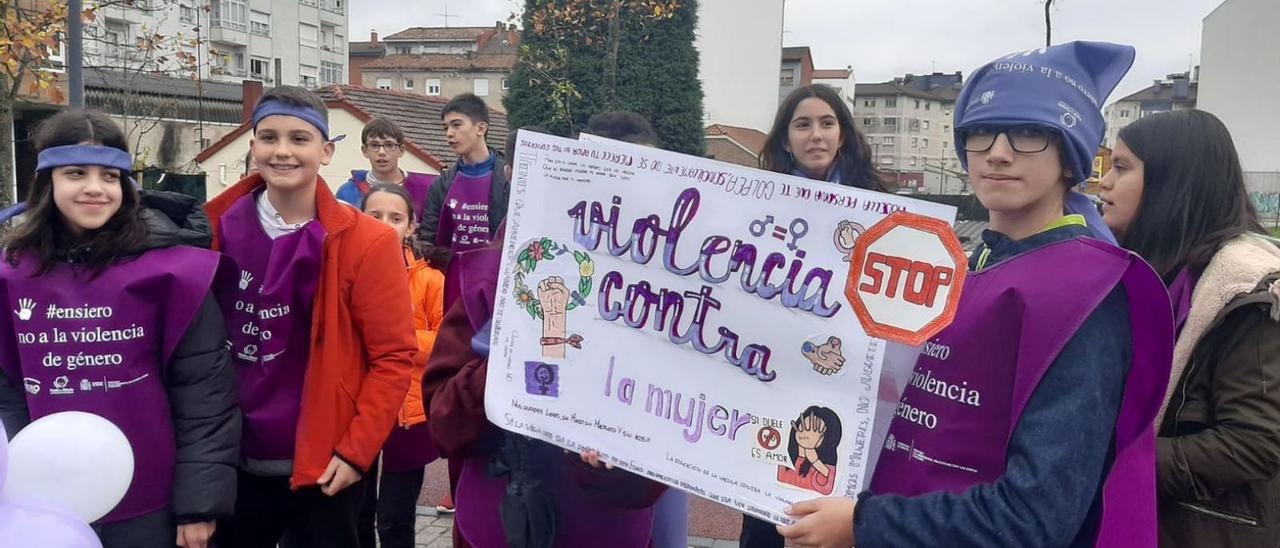 Un grupo de alumnos del IES Astures de Lugones sostiene una pancarta contra el maltrato. | L. Palacios