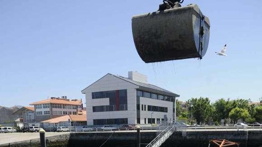 Descarga de mejillón en Vilaxoán, con el Intecmar al fondo. // N. Parga