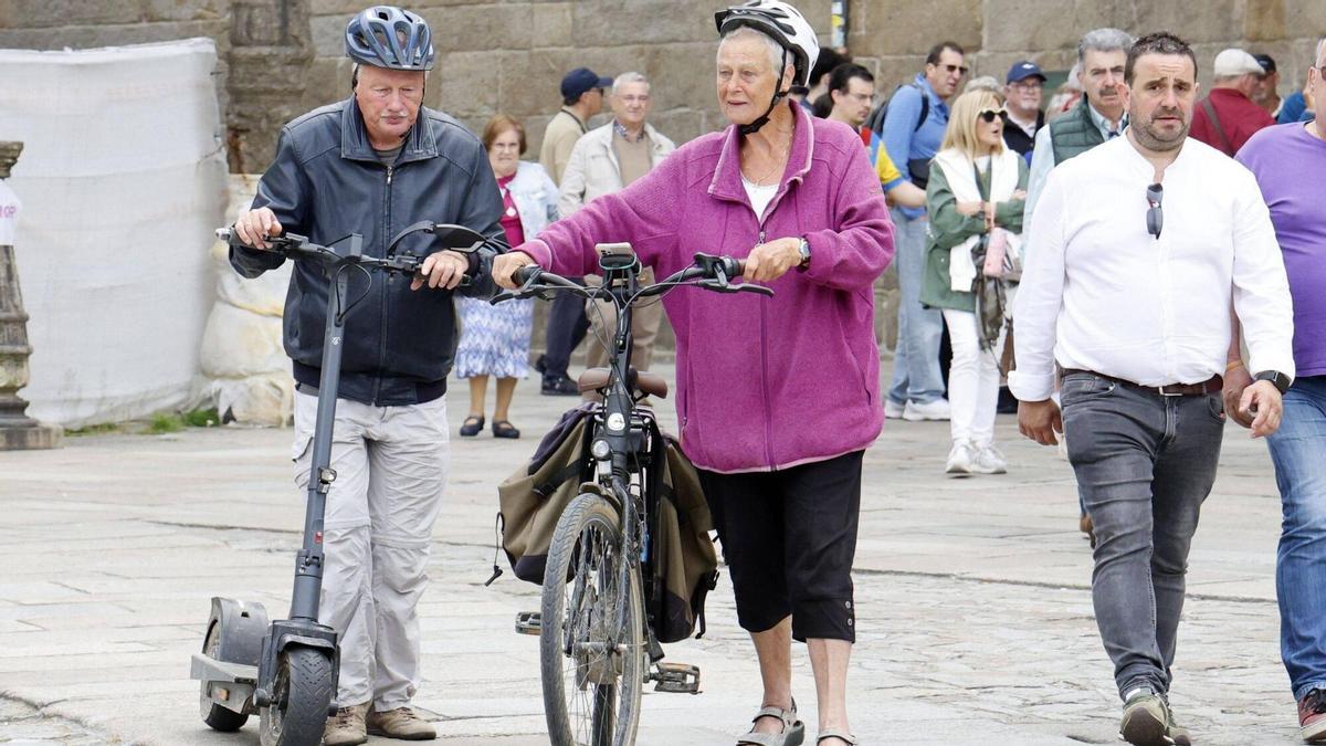 Dos turistas en patinete y bicicleta eléctrica por el casco histórico de Santiago