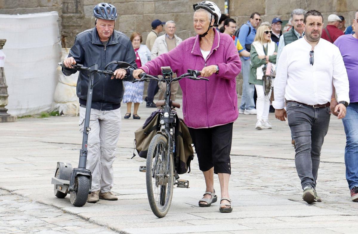 Dos turistas en patinete y bicicleta eléctrica por el casco histórico de Santiago
