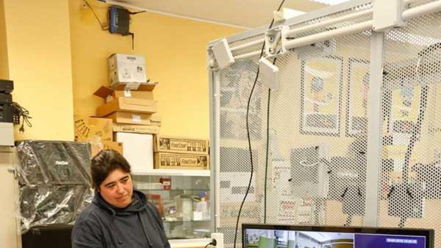 Dos alumnos con un panel de videovigilancia.