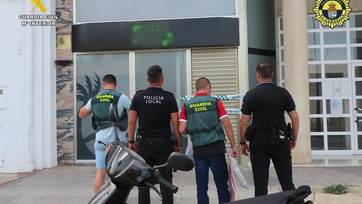 Agentes de la Guardia Civil y de la Policía Local de El Campello frente al local clausurado.