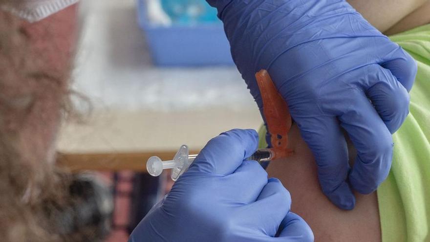 Una enfermera inyecta una vacuna a un paciente.