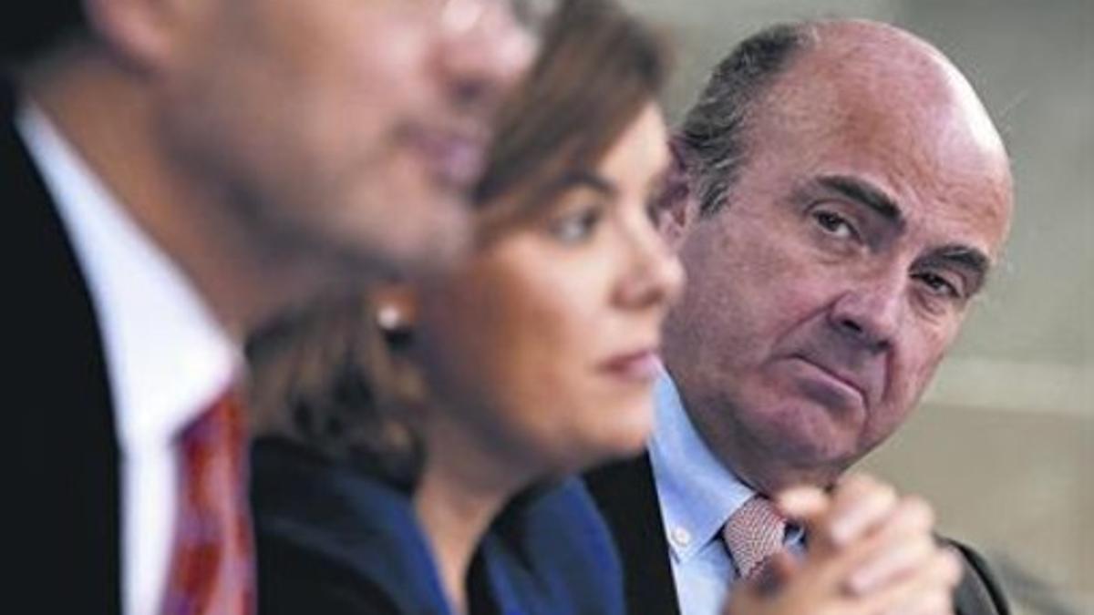 Rafael Català, Luis de Guindos y Soraya Saenz de Santamaria, ayer en la rueda de prensa tras el consejo.