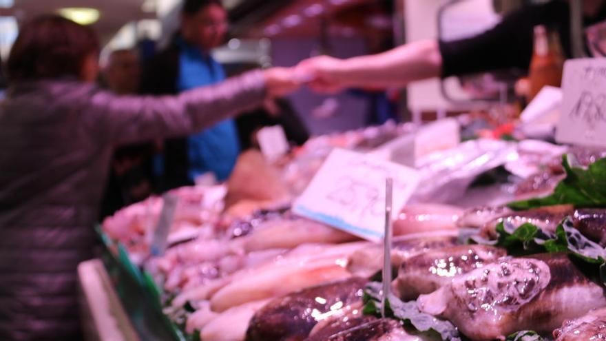 Un peixater atenent una clienta al Mercat del Poblenou de Barcelona el 13 de març de 2020