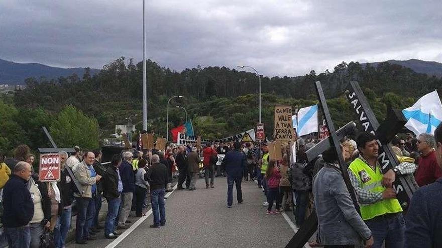 Vecinos de Arbo con pancartas y cruces este domingo en la manifestación contra el trazado.  // D.P.