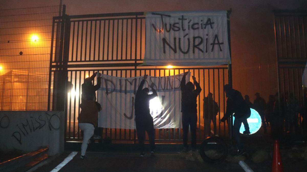 Empleados de Mas  d’Enric cuelgan una pancarta ante la cárcel