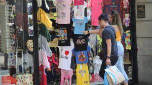 Dos jóvenes observan el escaparate de una tienda de recuerdos en Barcelona.