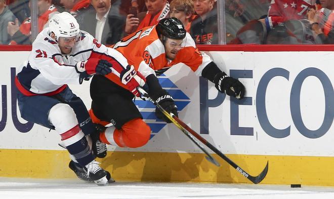 Garnet Hathaway # 21 de Washington Capitals y Carsen Twarynski # 81 de Philadelphia Flyers compiten por el disco en el primer período en el Wells Fargo Center en Filadelfia, Pennsylvania.