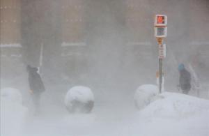 Dos funcionarios retiran con palas la nieve que obstaculiza la entrada del Ayuntamiento, en Buffalo.