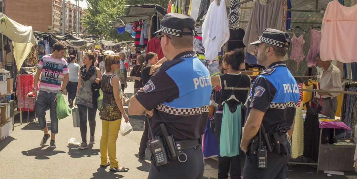 Dos agentes de la Policía Local vigilan el desarrollo del mercadillo de la ropa en la Cañada de la Vizana. | J. A. G.