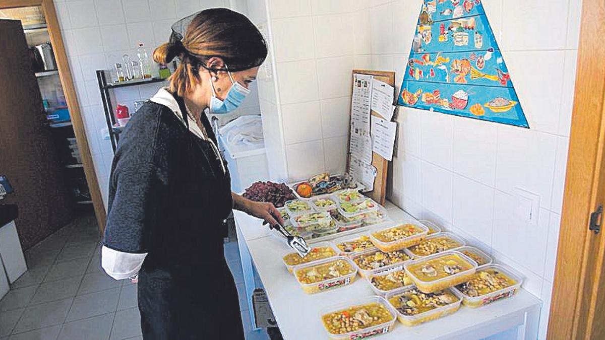 La cocinera prepara los menús para los usuarios.