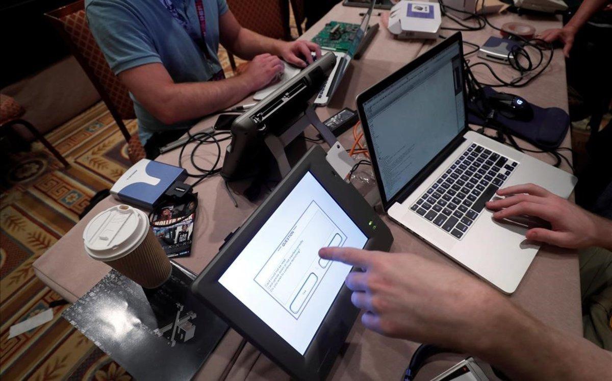 Unos 'hackers' intentan acceder a los datos de una máquina de votación durante una convención en Las Vegas.