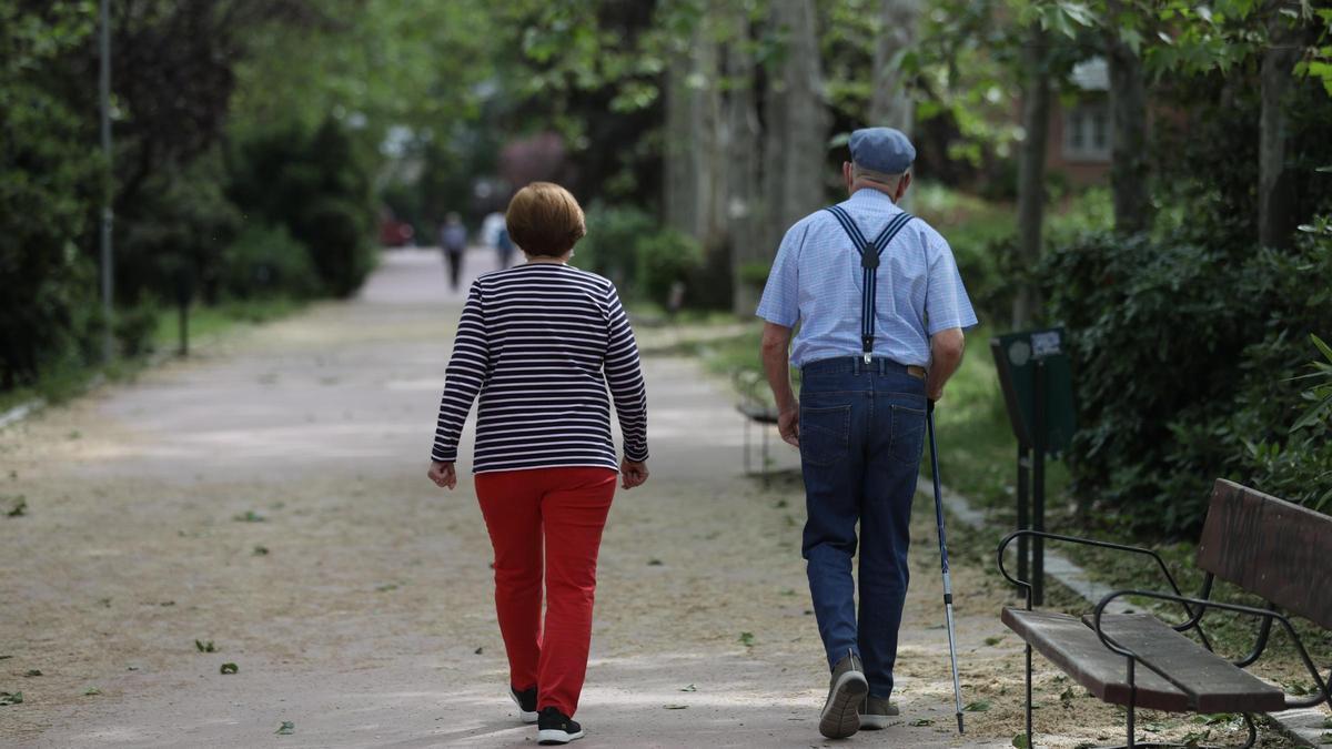 Una mujer y un hombre de edad avanzada caminan por Madrid.