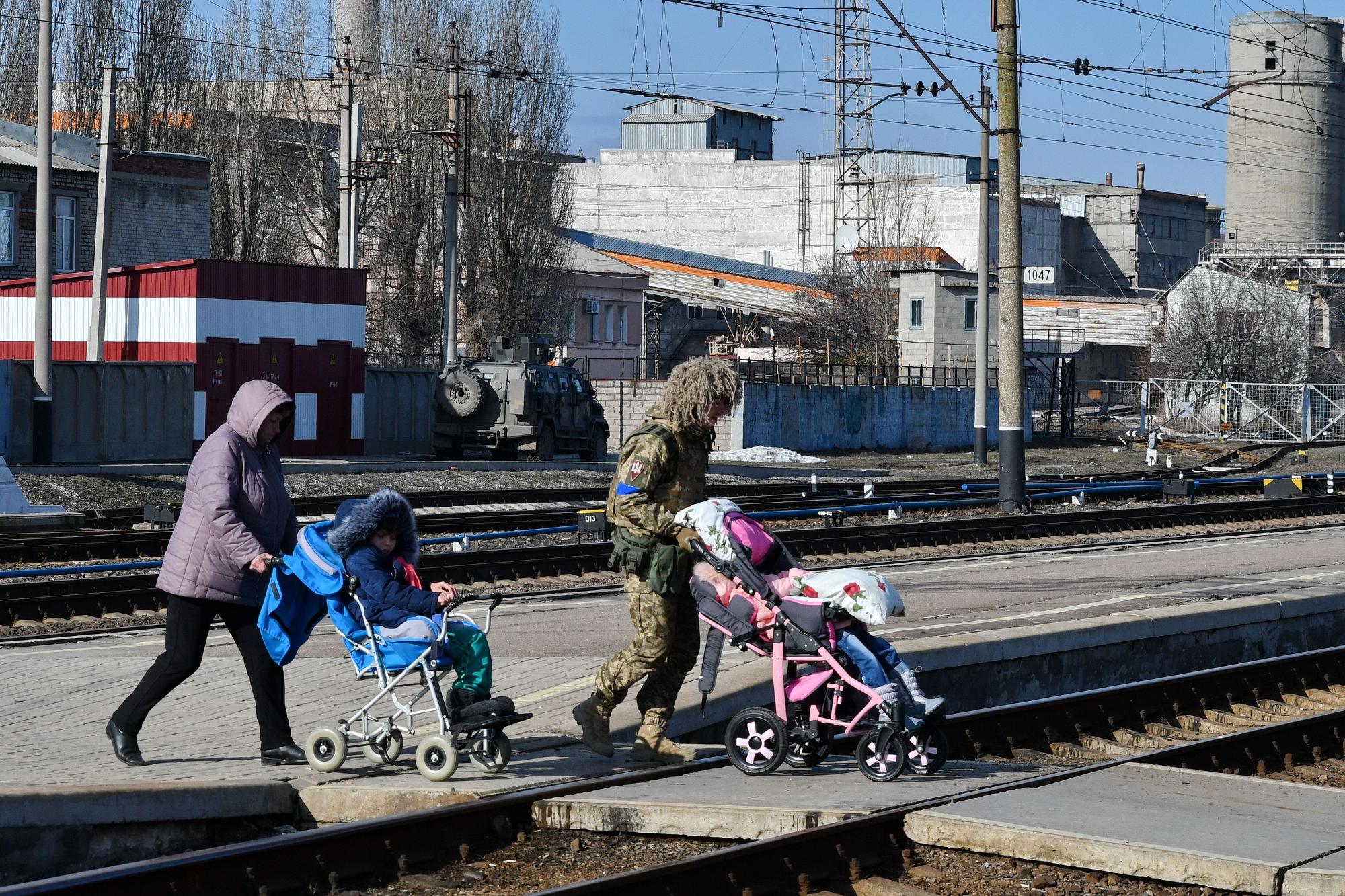 13 de marzo de 2022, Kramatorsk, Ucrania: Una mujer y un militar son vistos ayudando a varios niños a subirse a un tren.