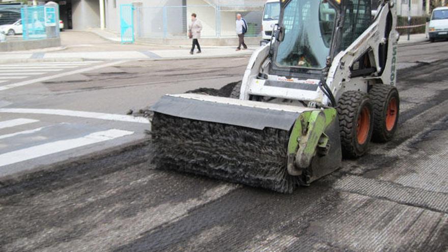 Una máquina lijadora prepara una calle para el asfaltado.
