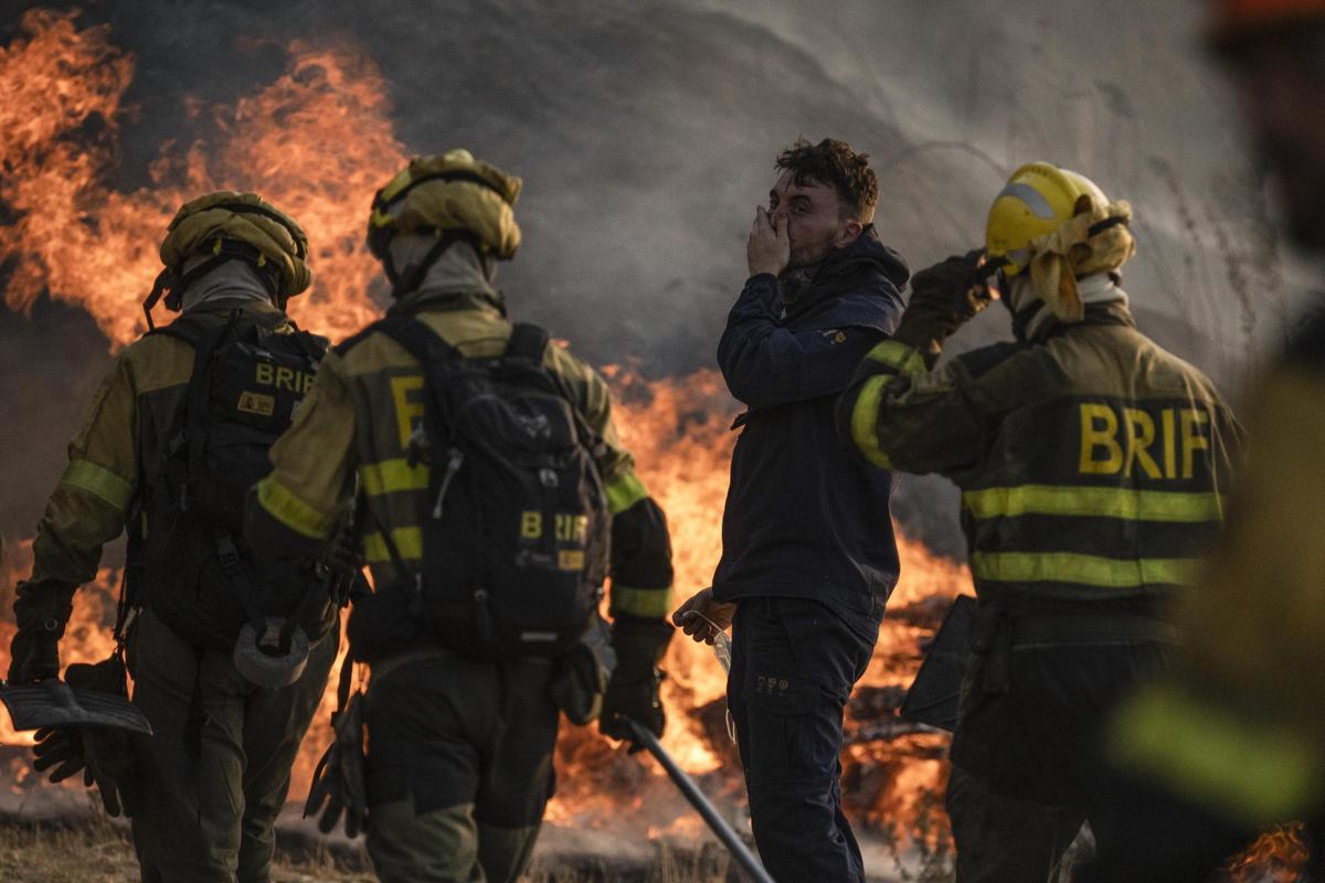 Bomberos forestales de la BRIF de Laza, junto a un vecino, en el incendio de Monterrei.