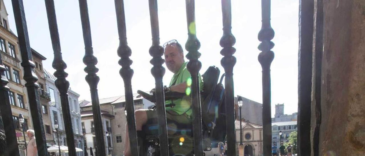 Marcos Gómez Gallego, en silla de ruedas, ante las escaleras de entrada a la Catedral de Oviedo.