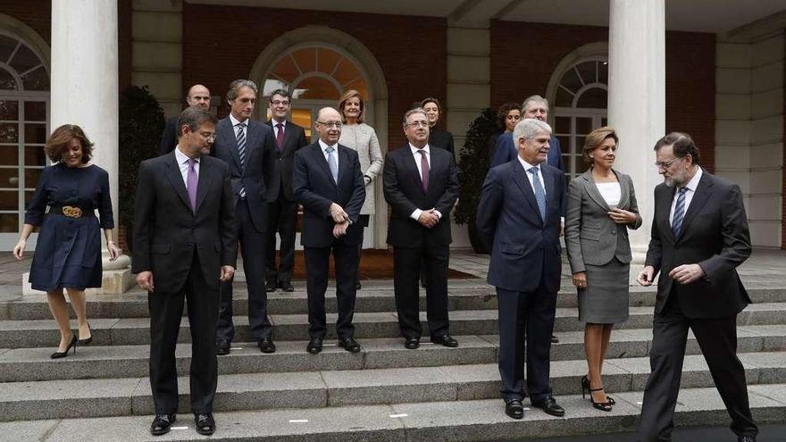 Mariano Rajoy, a la derecha, y Soraya Sáenz de Santamaría, a la izquierda, se apuran para colocarse en la foto de familia. // Efe