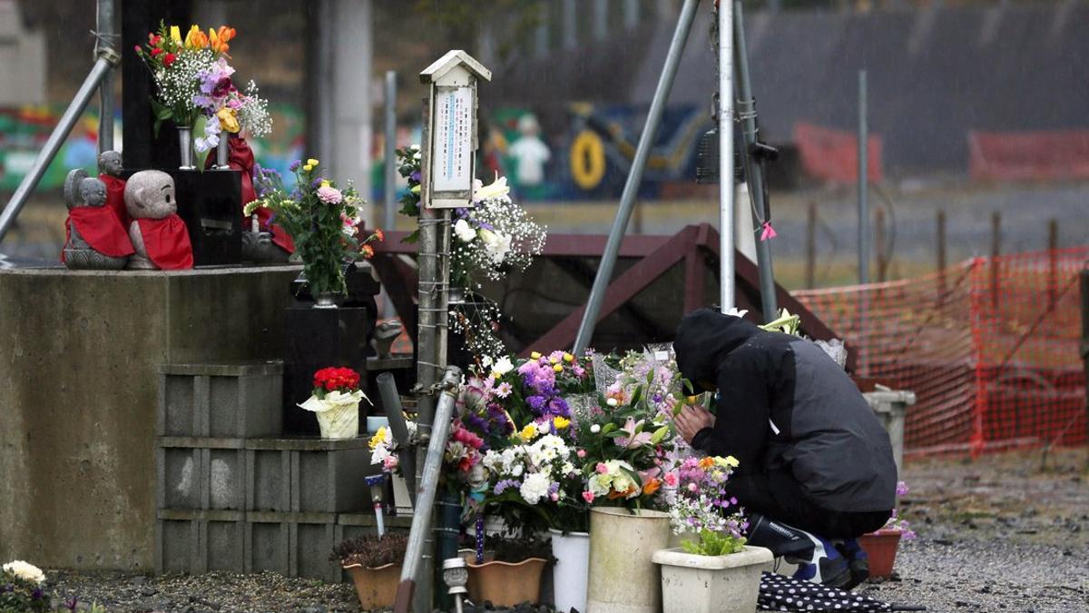 Un hombre ora en un altar de la víctimas del terremoto y tsunami en Fukusima, Japón.