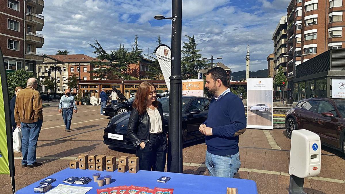 Begoña Honrado, coordinadora de la Escuela de Sostenibilidad, y el director general de Urbanismo, Jorge Fernández Mier, ayer, durante la exposición de vehículos eléctricos en la plaza de la Gesta. | LNE