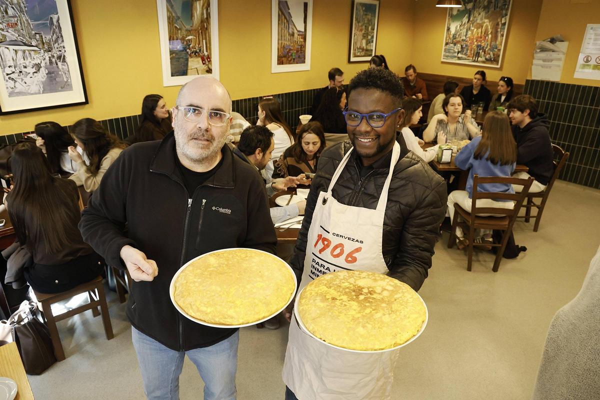 Carlos Suárez y Paulo Alexandre muestran las famosas tortillas del Bar La Tita, en el casco histórico de Santiago