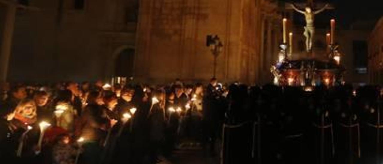 Fieles con velas delante del Cristo de la Misericordia.