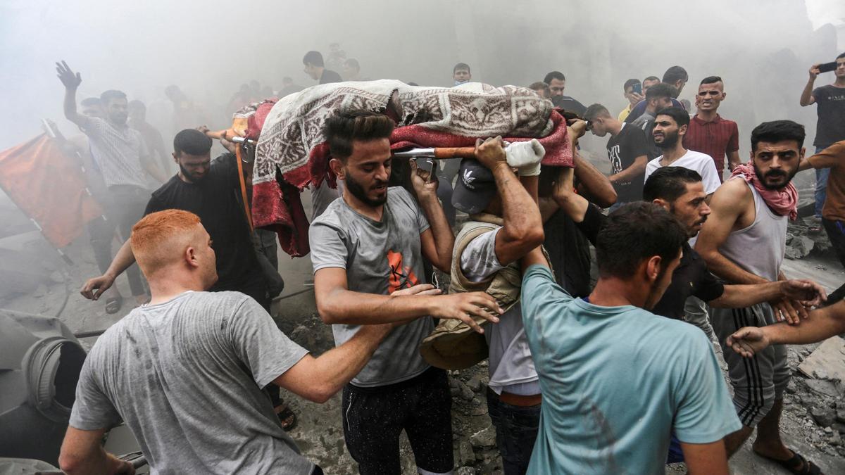 Varias personas cargan un cuerpo tras un ataque aéreo de Israel en la franja de Gaza, el 9 de octubre.