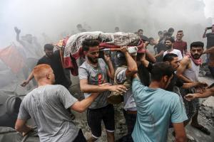 Varias personas cargan un cuerpo tras un ataque aéreo de Israel en la franja de Gaza, el 9 de octubre.