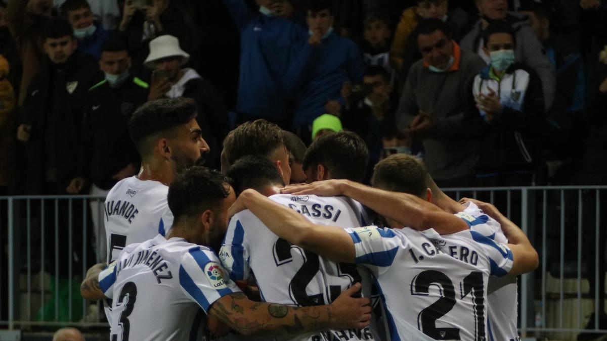 Jugadores del Málaga CF celebrando el gol de Brandon Thomas ante la atenta mirada de los aficionados.