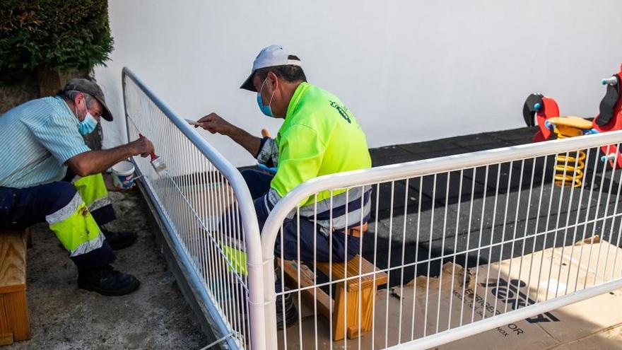 Dos operaris pintant una tanca