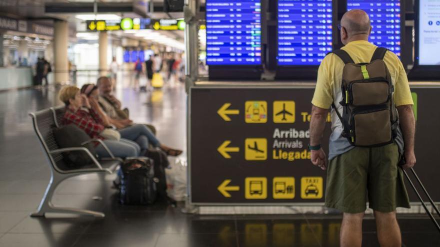 Un home mira un panell de sortides a l’aeroport del Prat en una fotografia d’arxiu. | EUROPA PRESS