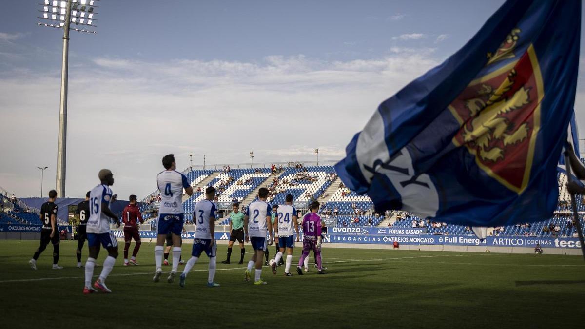 Los jugadores del Real Zaragoza salen al Ibercaja Estadio bajo la bandera del club.