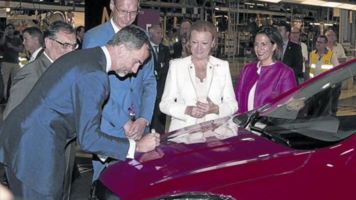 Felipe VI firma en el capó del primer Opel Mokka producido en serie en la fábrica de General Motors en Figueruelas.