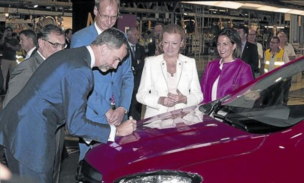 Felip VI firma al capó del primer Opel Mokka produït en sèrie a la fàbrica de General Motors a Figueruelas.