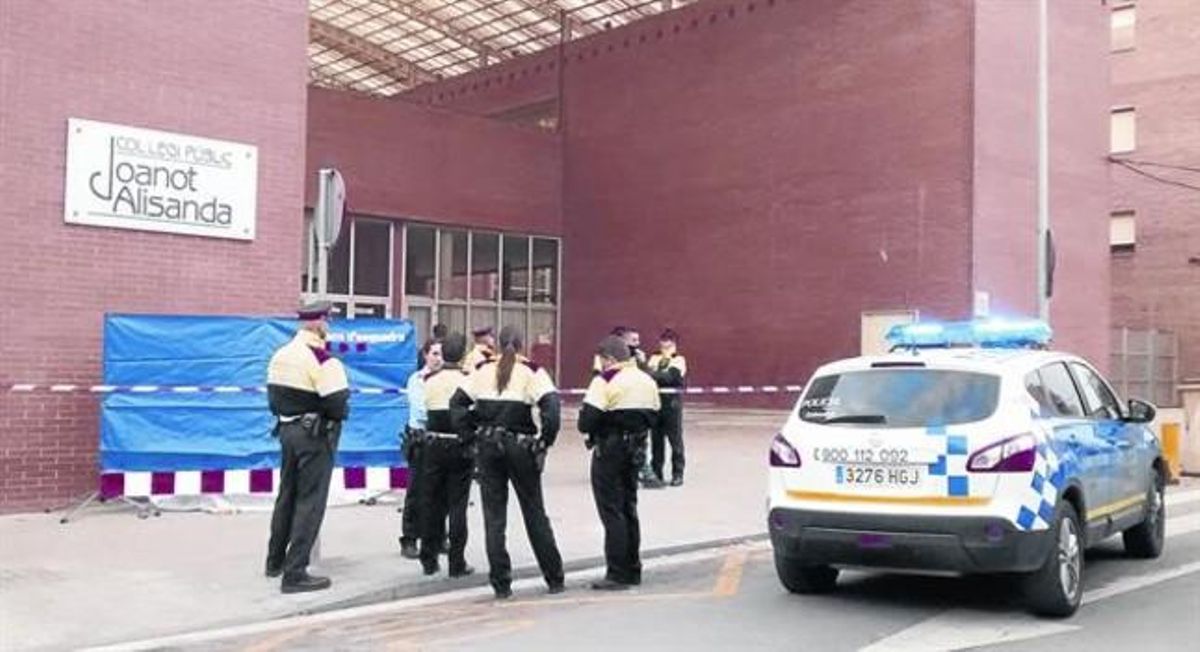 Un grup d’agents dels Mossos custodien el cos, tapat amb un llençol, darrere una lona policial, ahir a Sabadell.