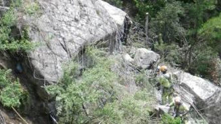 Operaris instal·lant la malla per reconduir les roques caigudes.