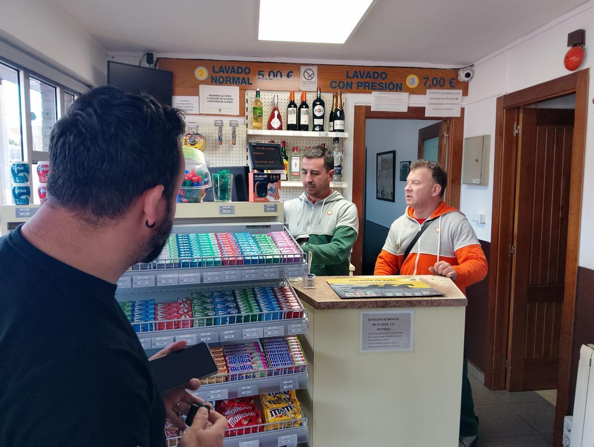 Juan Traviesa y Paco Santoveña, atienden a un cliente en la gasolinera De la Vega.