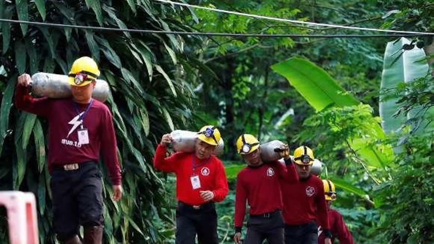 Miembros de los servicios de rescate portando botellas de oxígeno.