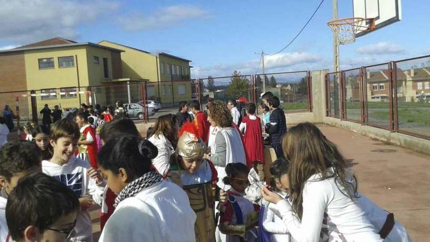 Alumnos consumen castañas durante la fiesta y, a la izquierda, un niño recibe el fruto más típico de la estación otoñal.