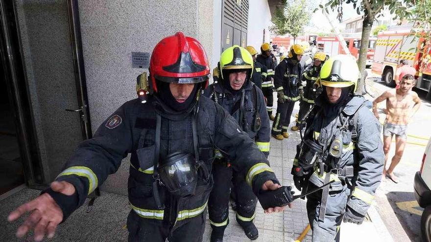 Los bomberos replanteando el trabajo ante la mirada del inquilino del piso incendiado. // Alfredo Hernández