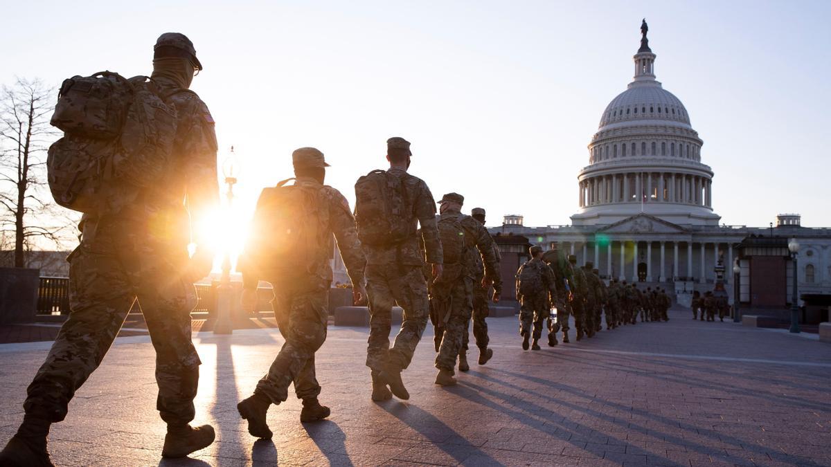 Una columna de miembros de la Guardia Nacional se dirige al edificio del Capitolio en Washington.