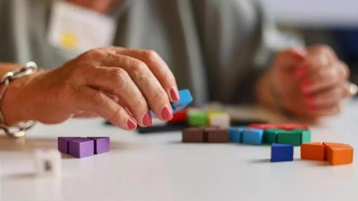 Una mujer con alzéimer realiza una actividad en un centro de día.