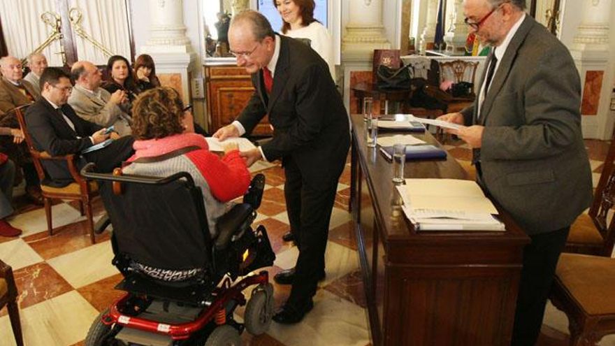 El alcalde de Málaga y la edil de Hacienda entregan la acreditación para recibir las ayudas al IBI.