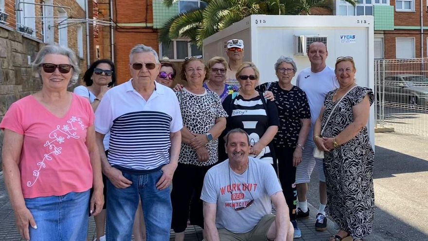 Por la izquierda, Adela Rodil, María Isabel Bernardo, Salvador López, Charo Valle, Mar Corveiras, María Antonia Mateos, Eduardo Roza, Miguel Butrón, Julia Bella, Caridad García, Andrés Cabanas y Begoña Corveiras posan ante uno de los edificios de la primera fase de obra de la Sindical de Contrueces. | ANDREA SANZ-YUS