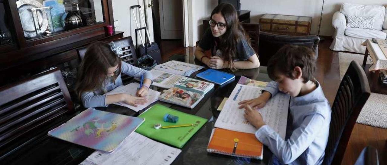 Carlota Sánchez (a la derecha) supervisa el trabajo de Alejandro y Alcázar, ayer, en el domicilio de los pequeños.