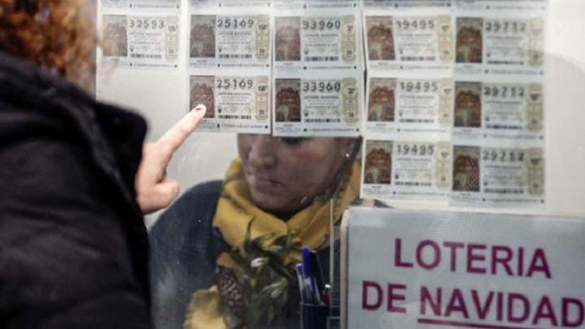 Una persona compra un décimo de Lotería de Navidad