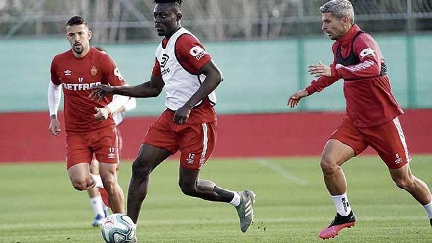 Baba conduce el balÃ³n ante la presiÃ³n de Salva Sevilla y Aleksandar Trajkovski en un entrenamiento en Son Bibiloni.