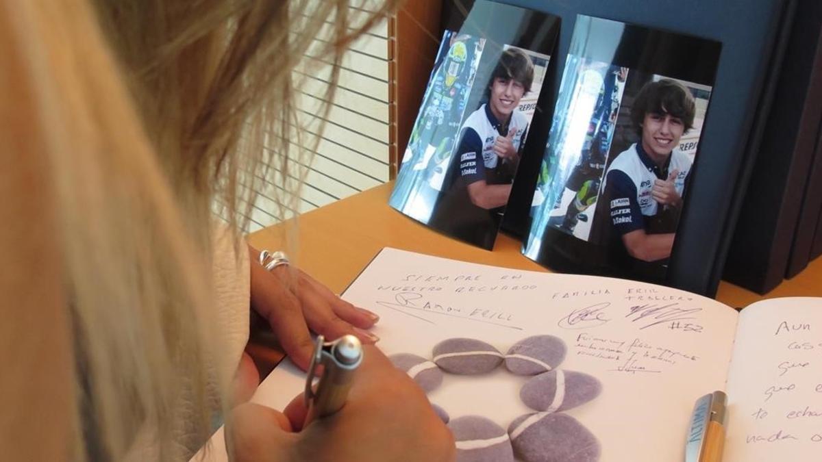 Una mujer estampa su firma en el libro de Andreas Pérez, en el Tanatorio de Ronda de Dalt.