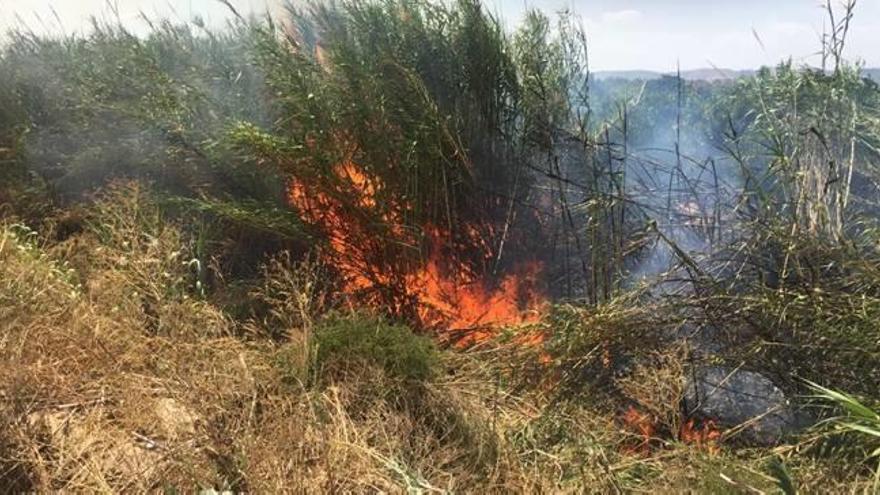 Vecinos observan el control de un incendio, este verano.